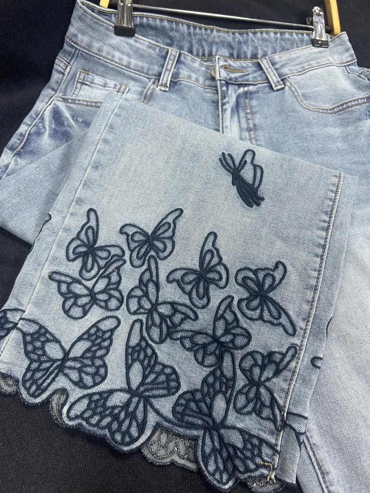 Close-up of layered butterfly embroidery at the hem