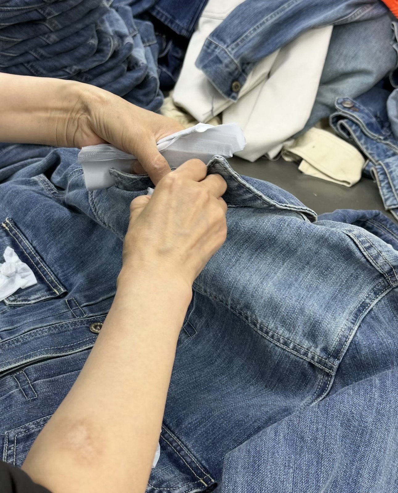 Hands finishing or checking a denim garment
