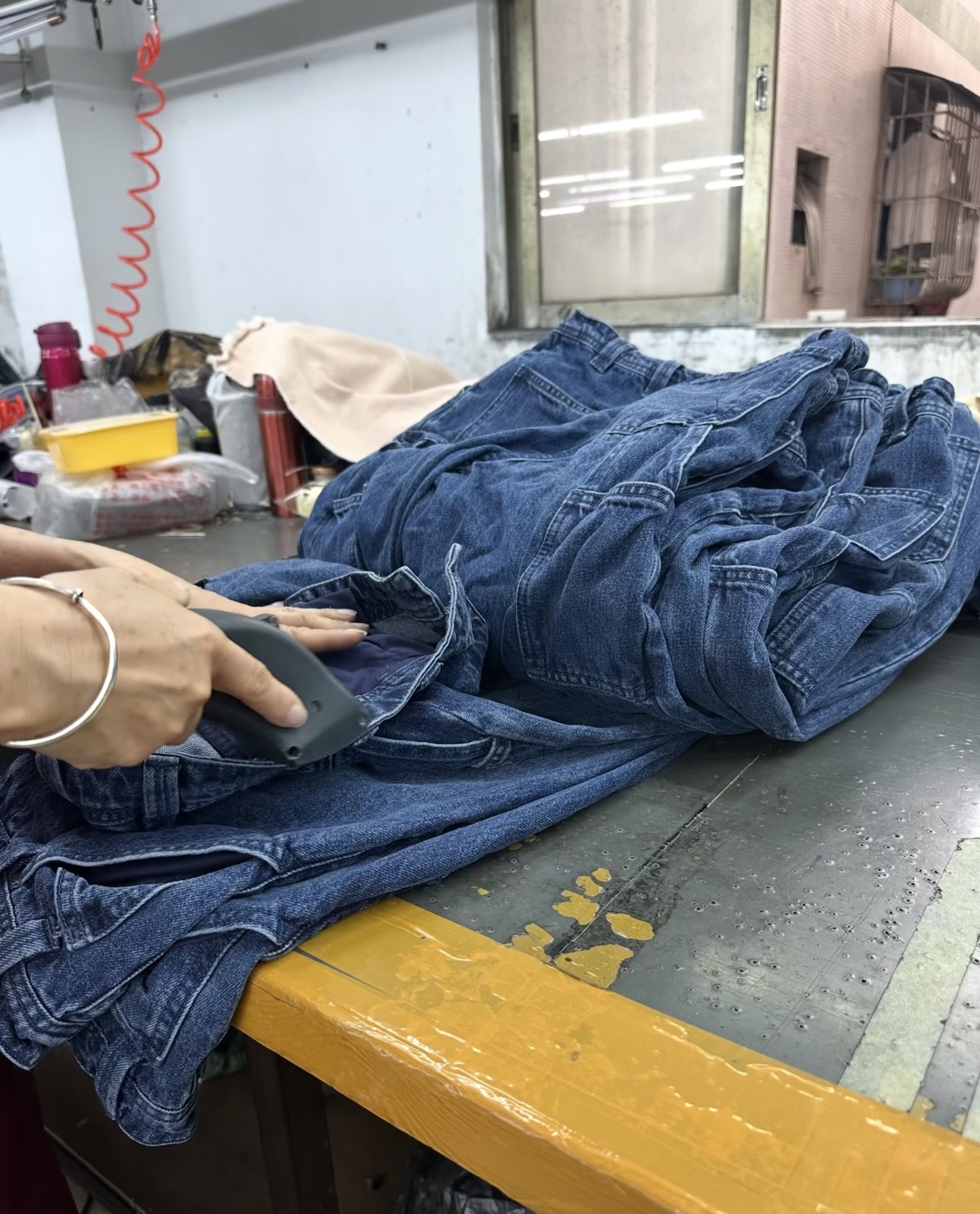 Handheld inspection of denim garments on a work table