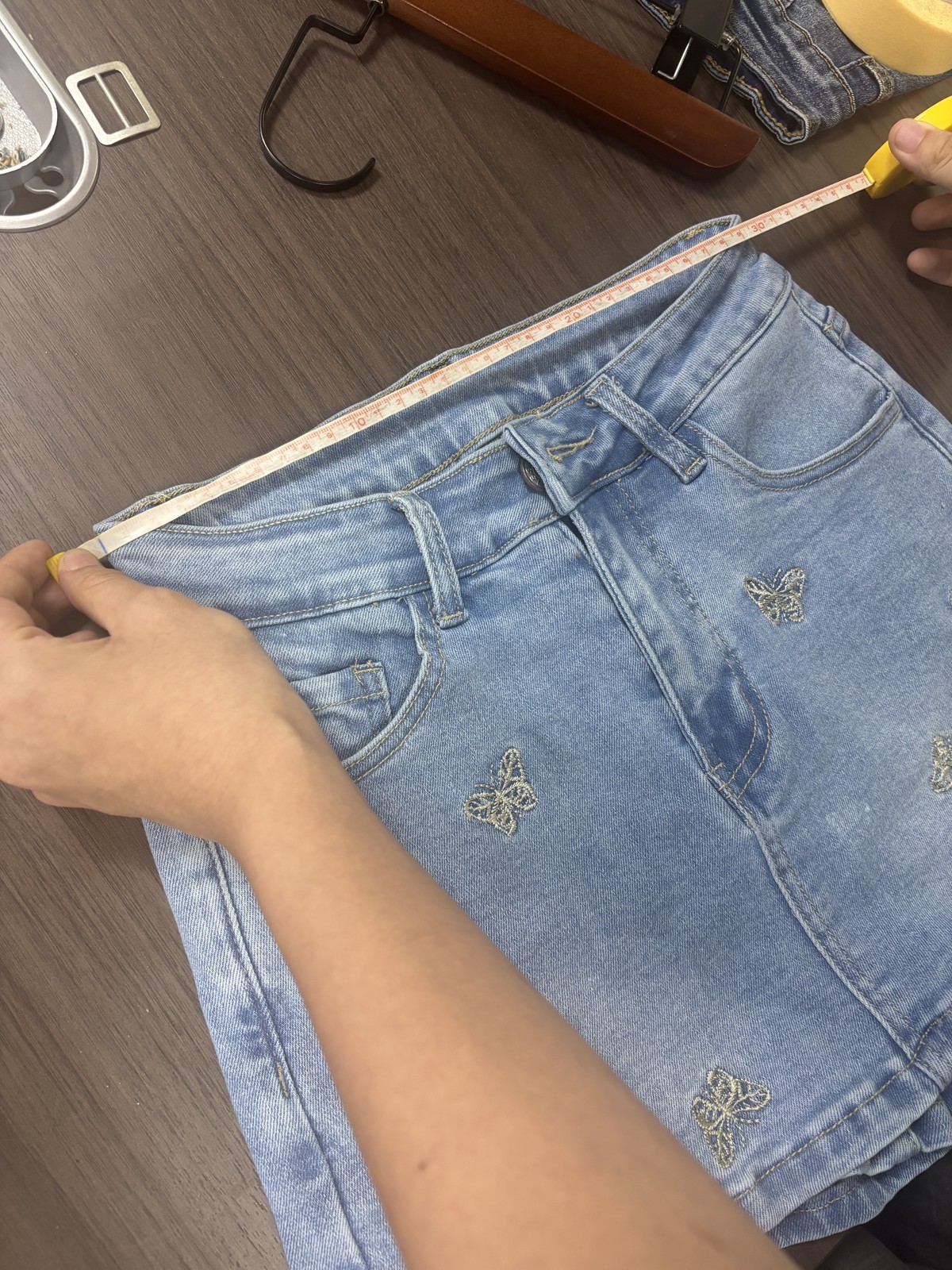 Waist measurement being checked on a finished denim garment